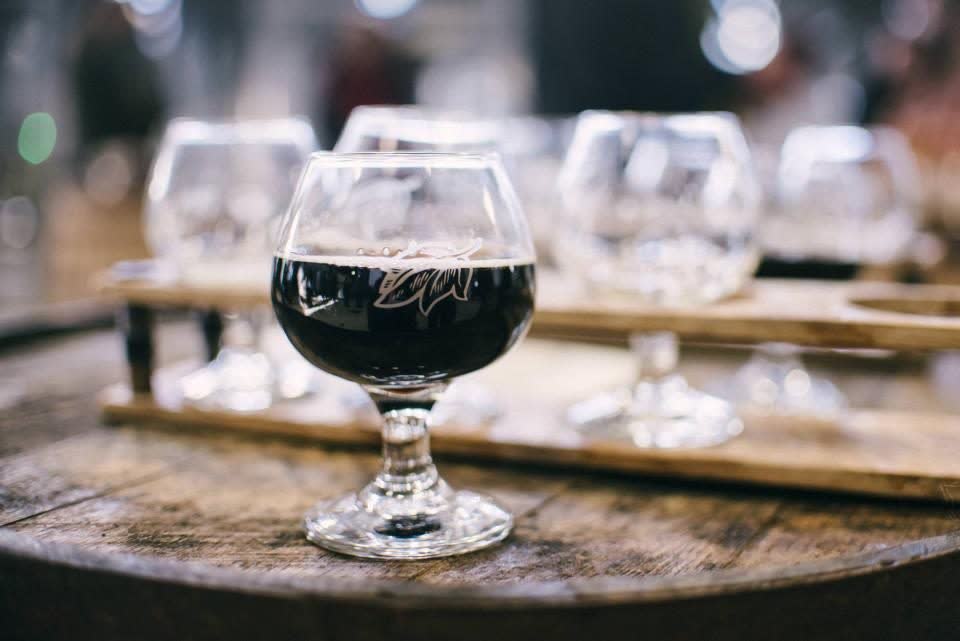 A glass of red wine on a wooden barrel, ready for tasting